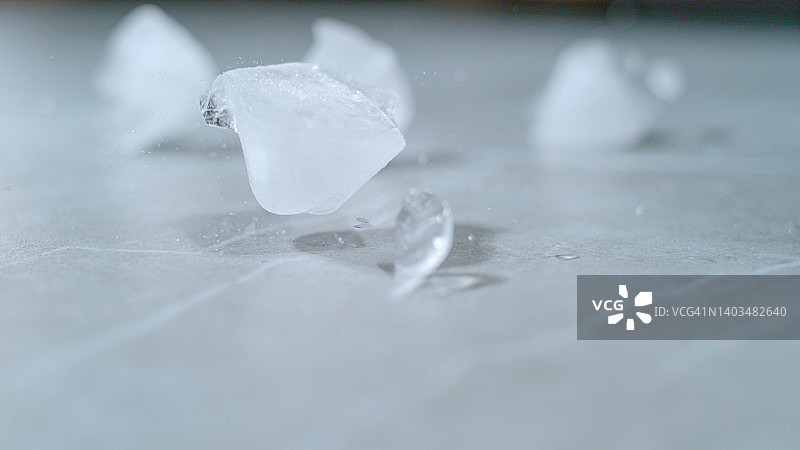 宏观视角，自由度:融化的冰块散落在空荡荡的餐桌上。图片素材