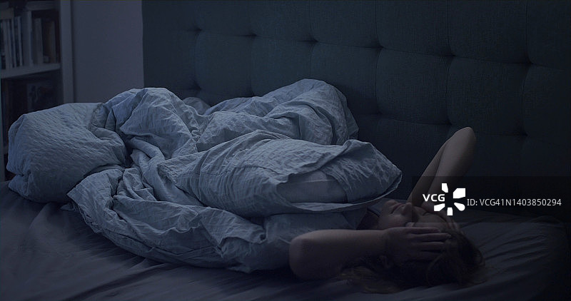 女人在床上因失眠而睡不着图片素材