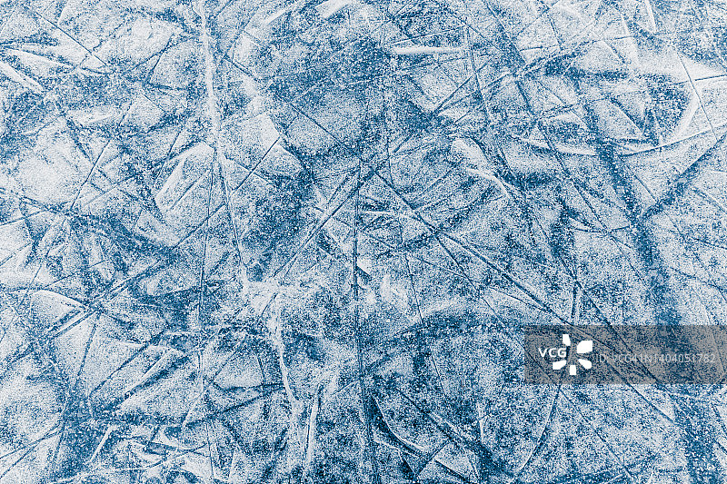 冬天的背景，冰冻的湖面上有冰鞋的划痕。冬季运动纹理。图片素材