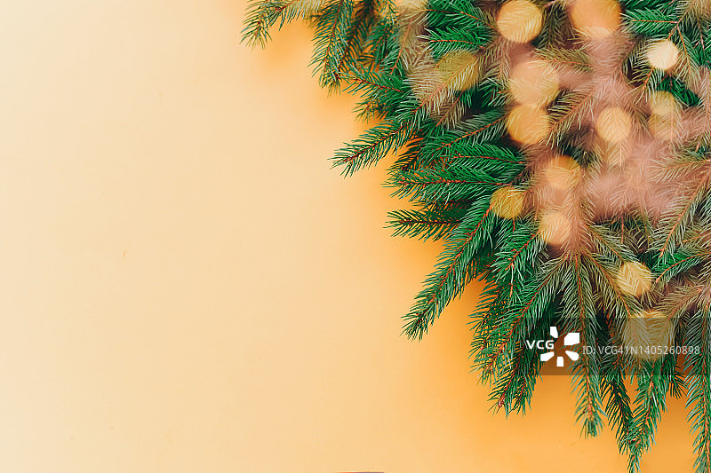 美丽的橙色背景与圣诞树的树枝。新年。圣诞节。图片素材