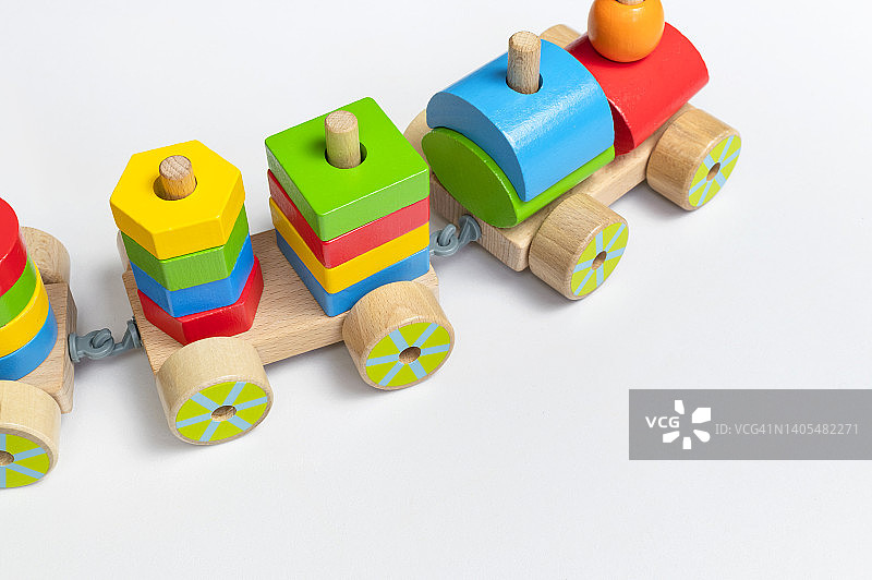 白色背景的彩色方块木制火车。由天然木材制成的彩虹色儿童玩具。环保玩具，游戏，不含塑料。婴幼儿玩具。平躺图片素材