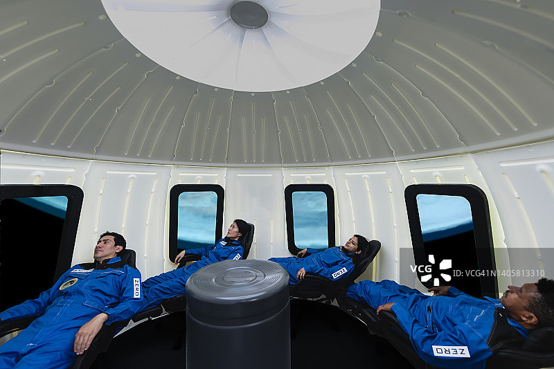 商业太空旅行者坐在宇宙飞船的座位上。图片素材