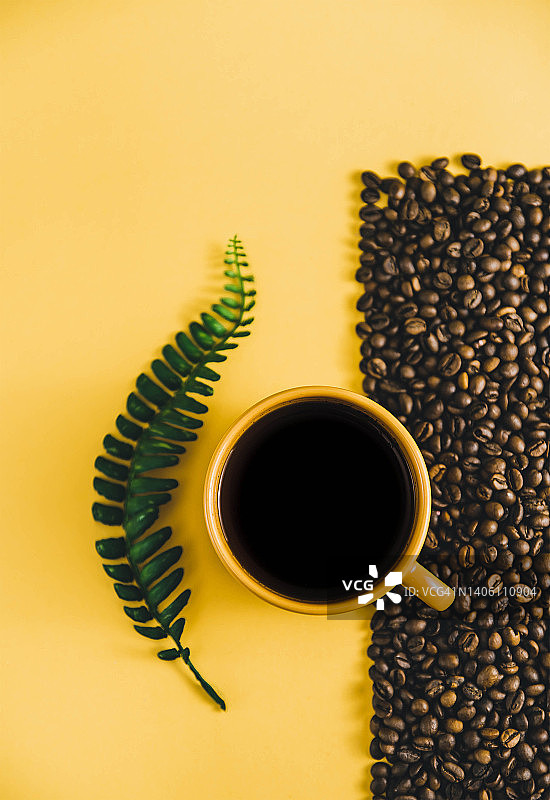 咖啡的背景。咖啡杯。用咖啡豆复制空间。咖啡豆放在餐桌上。咖啡豆的特写。橙杯加黑咖啡图片素材