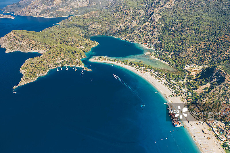 蓝色泻湖鸟瞰图，碧蓝的大海，白色的沙滩，带着遮阳伞和游船。Oludeniz Mugla,土耳其。图片素材
