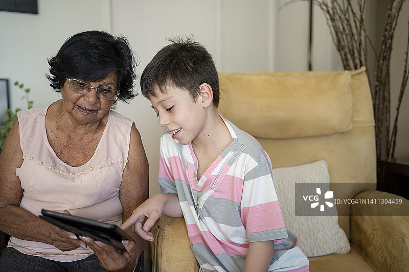 奶奶和孙子在家用平板电脑图片素材