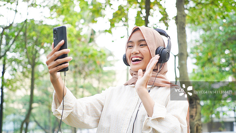 年轻女子使用智能手机进行电话会议图片素材