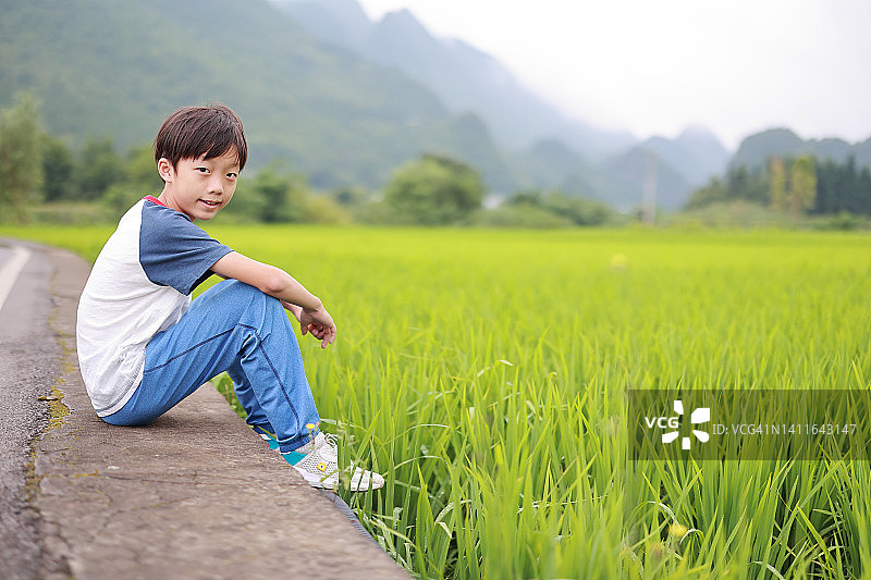 一个旅游男孩走在稻田里图片素材