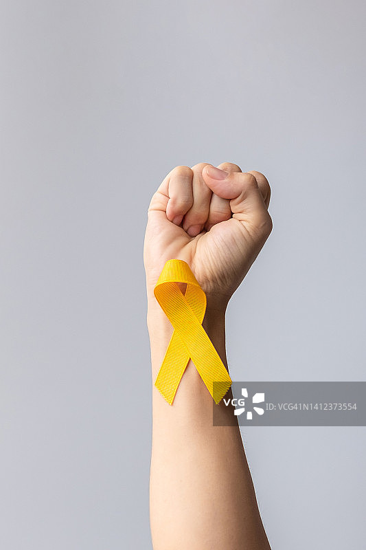 预防自杀日，儿童，肉瘤，骨和膀胱癌宣传月，支持人们生命和疾病的黄丝带。儿童保健和世界癌症日的概念图片素材