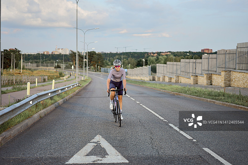 年轻女子在路上骑自行车图片素材