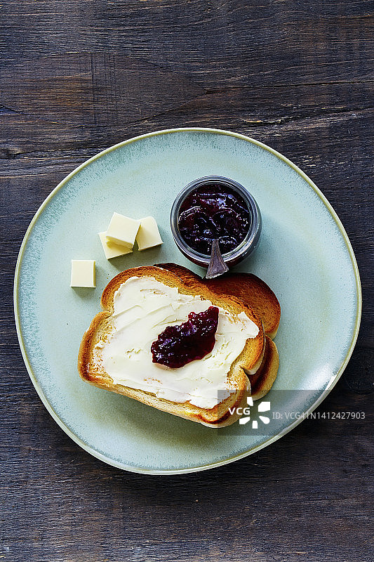 俯瞰全谷物面包吐司黄油和果酱的传统早餐在木制背景图片素材