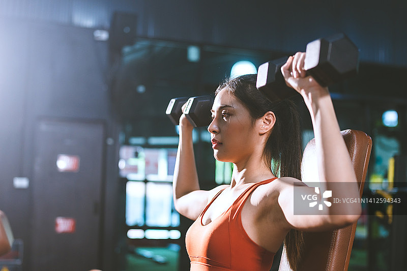 年轻的亚洲女性在健身房里锻炼，为了塑造美丽苗条的身材，在运动生活方式中锻炼运动女性的健康，在快乐中做体重积极健康的迷人女孩图片素材