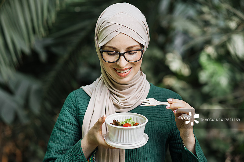 欢快的穆斯林妇女在温泉吃健康的午餐。图片素材