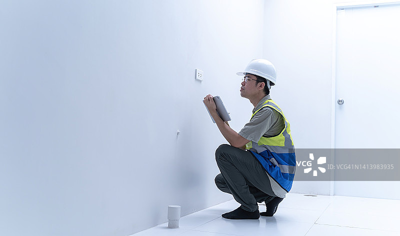 亚洲男工程师检查新房内部建设。图片素材