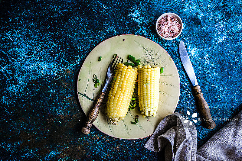 俯瞰两个煮玉米棒子，葱和粉红色的喜马拉雅盐图片素材