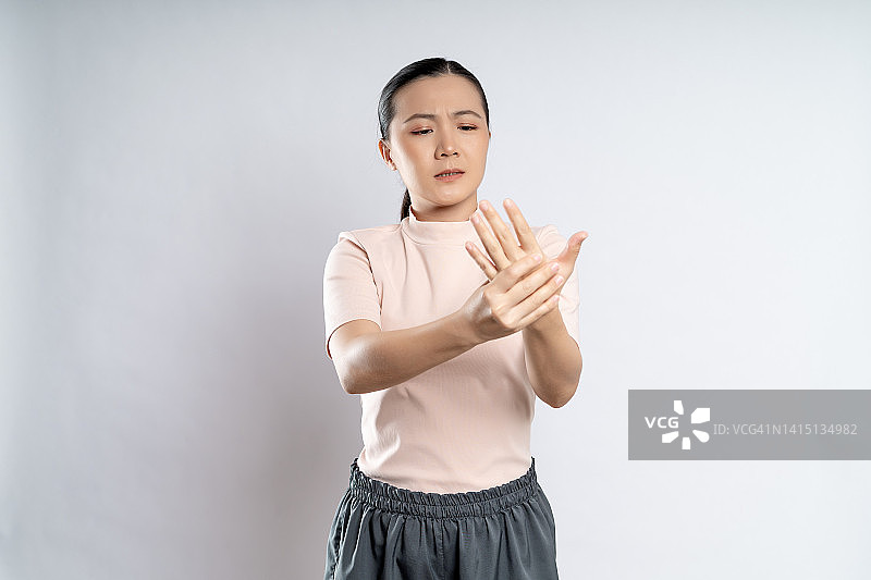 一名亚洲女性因身体疼痛孤立地站在白色背景上。图片素材