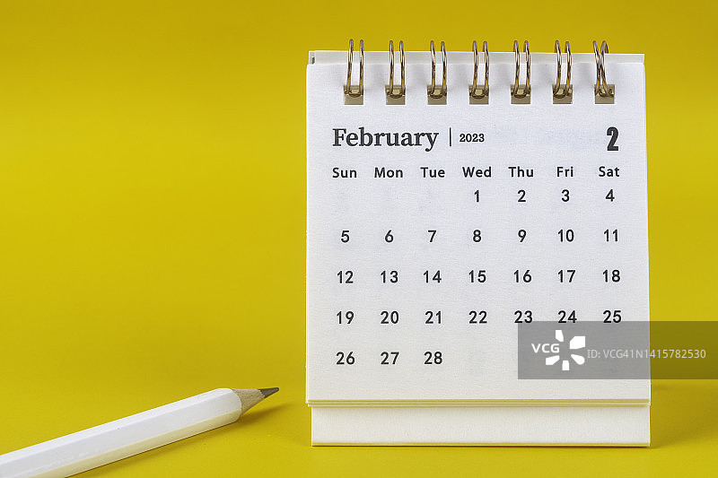 2023年2月是组织者计划和截止日期，用白色铅笔在黄色纸的背景上。图片素材