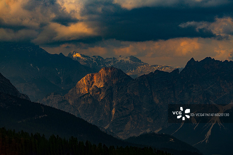 意大利南蒂罗尔，著名的白云石山峰在夏季日落时美丽的金色晚霞中发光图片素材