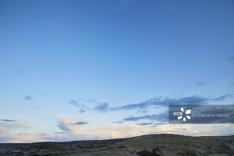 日落时，沙丘映衬着蓝天白云图片素材