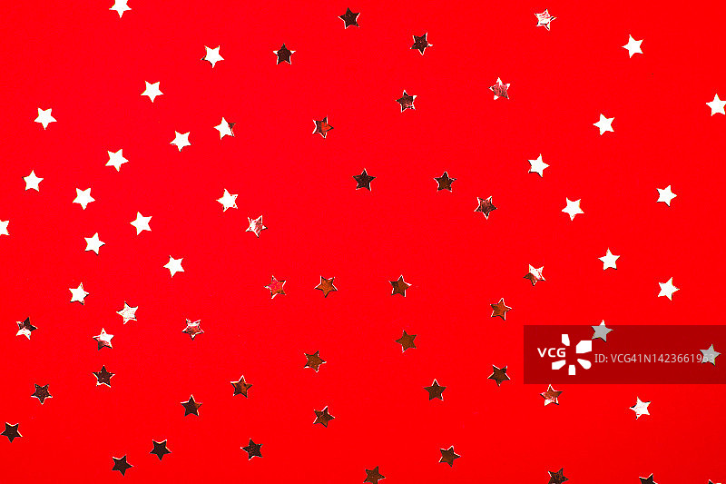 红色背景与闪亮的星星在平坦的铺设风格。圣诞快乐和新年快乐的概念。图片素材