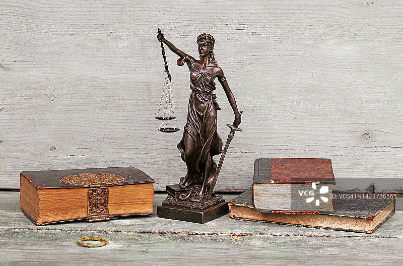 木制背景上的正义人物和旧书图片素材