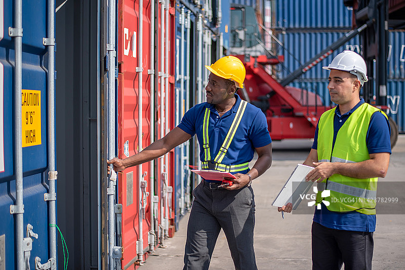 仓库后勤人员在货物集装箱装运时检查货物货轮上的产品。图片素材