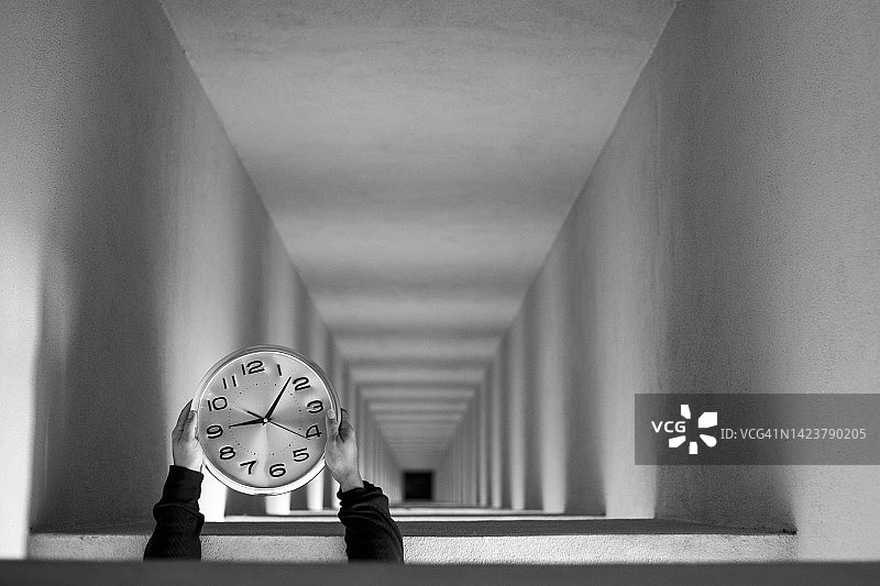 裁剪的手，人拿着时钟对空的未来主义走廊图片素材