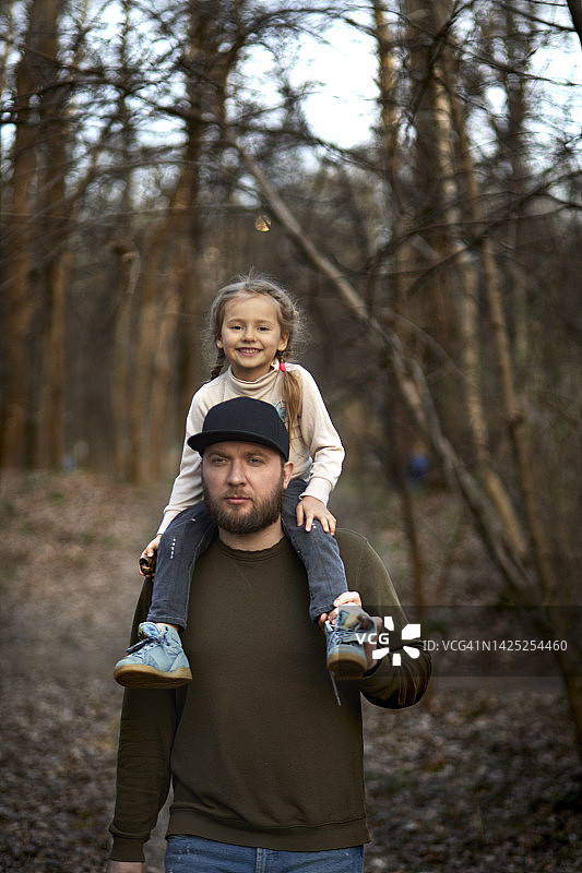 父亲在森林里把小女儿扛在肩上图片素材