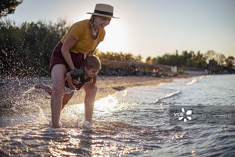 一个女人和一个男孩在海水中嬉水。图片素材