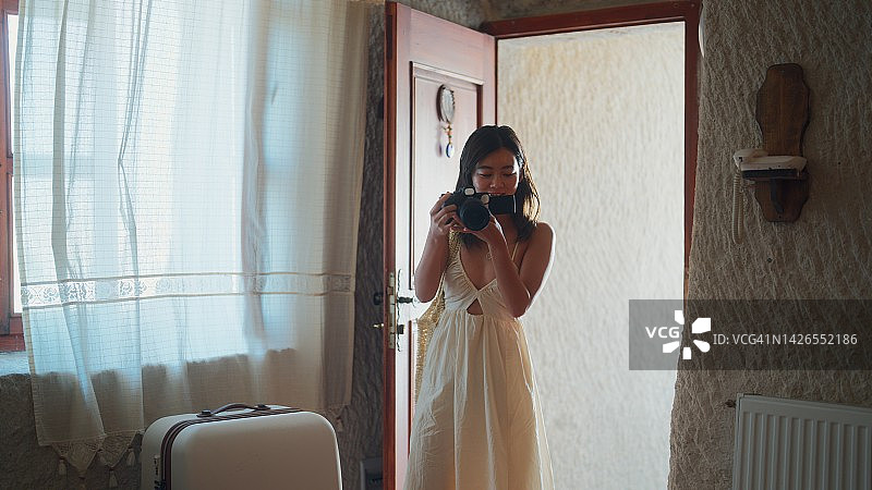 女性旅游视频博主在社交媒体上有影响力，用她的相机视频博主介绍酒店的房间图片素材