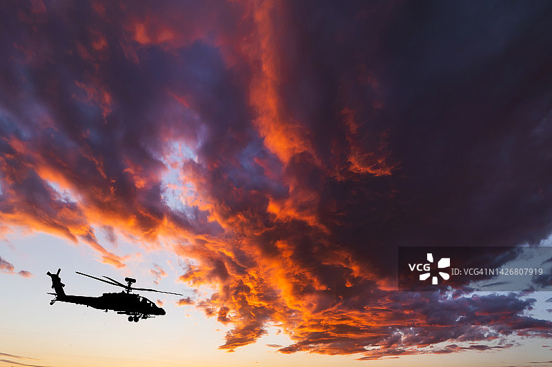 日落天空背景下的军用直升机图片素材