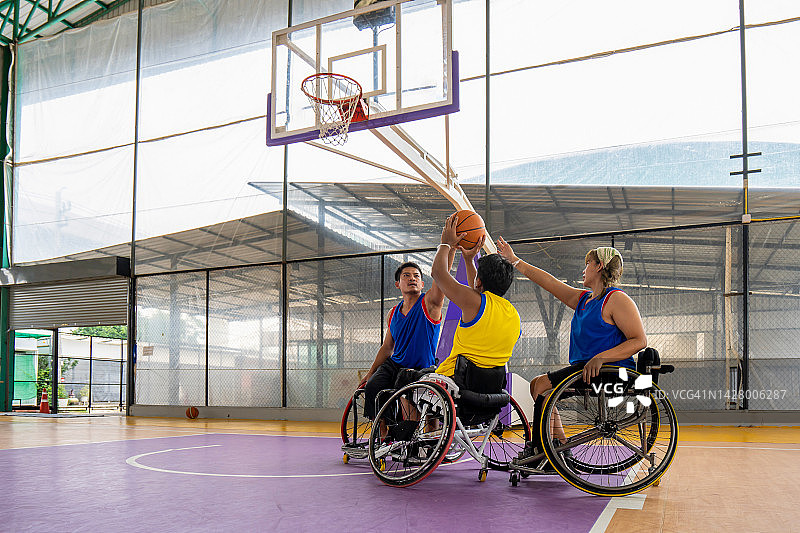 在一场轮椅篮球比赛中，轮椅篮球运动员试图阻挡另一名运动员。图片素材