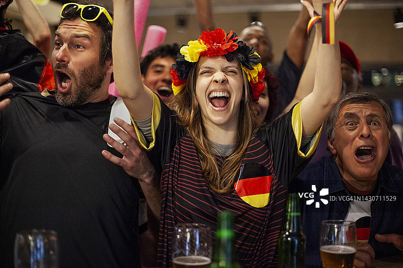 一名快乐的德国女子在拥挤的酒吧庆祝国家队比赛的结果图片素材