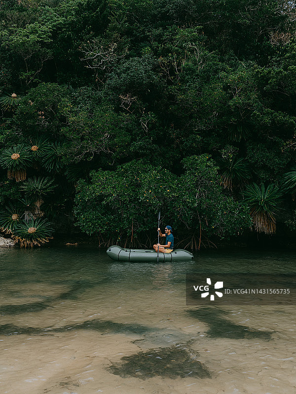 日本冲绳岛，一名男子在红树林河上划船图片素材