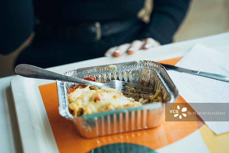 用铝箔制成的盒饭，里面的食物加热后就可以食用了。在餐厅休息一下吃午饭。咖啡装在托盘上的白色杯子里。“零浪费”的概念图片素材