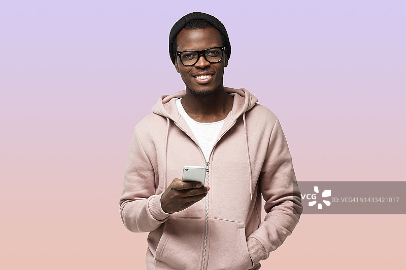 身穿便装、戴着眼镜的非洲裔美国人，紫色背景照片，手持手机图片素材