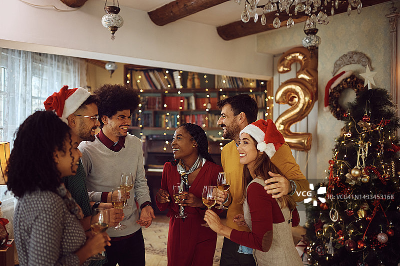 多种族的快乐的人们在庆祝新年的家庭聚会上交谈。图片素材