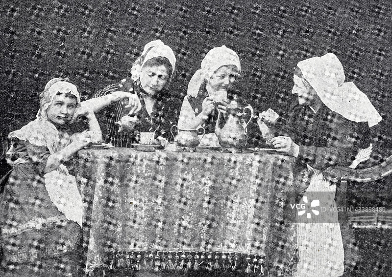 咖啡闲言碎语桌，三个女人和一个女孩在聊天，玩得很开心图片素材
