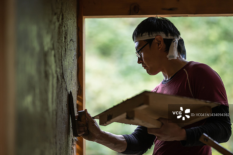 一对木匠夫妇和他们的朋友们以传统的日本方式装修他们的房子。图片素材