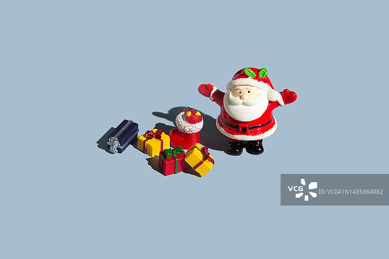 圣诞老人与圣诞礼物的蓝色背景。最小的圣诞假期概念。平铺，俯视图，复制空间图片素材