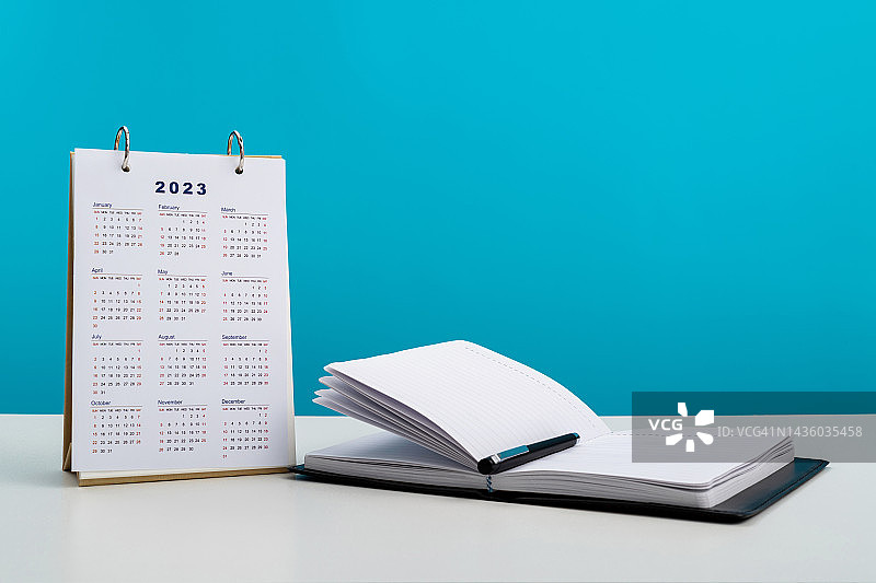 2023日历和记事本放在桌子上图片素材