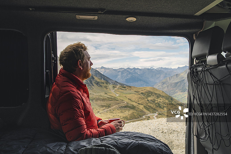 一只成熟的雄性从他的露营车上欣赏山景图片素材