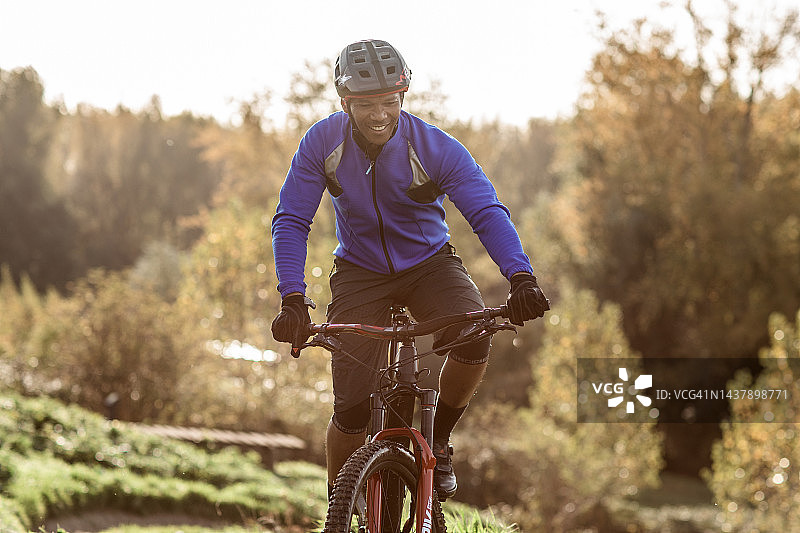 一个独自在小路上冒险的黑色山地自行车手图片素材