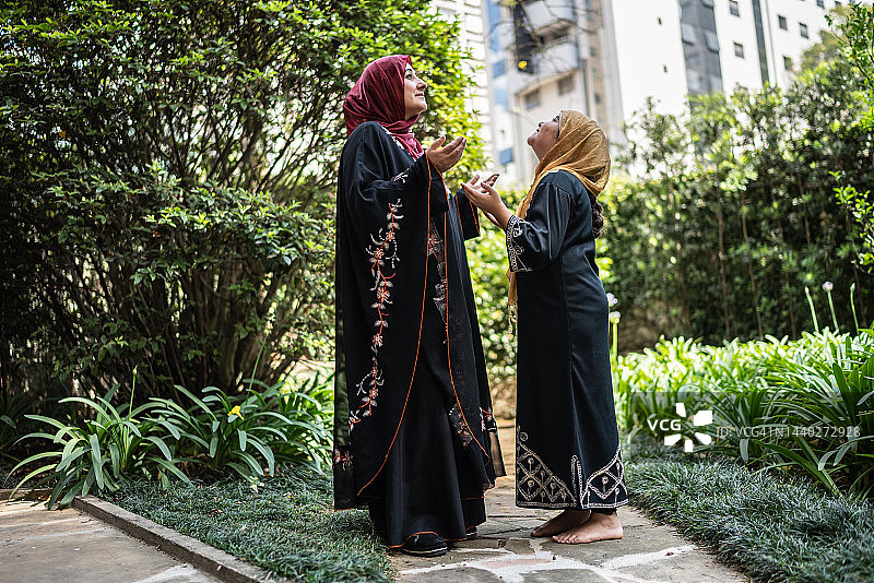母亲和女儿祈祷仰望图片素材