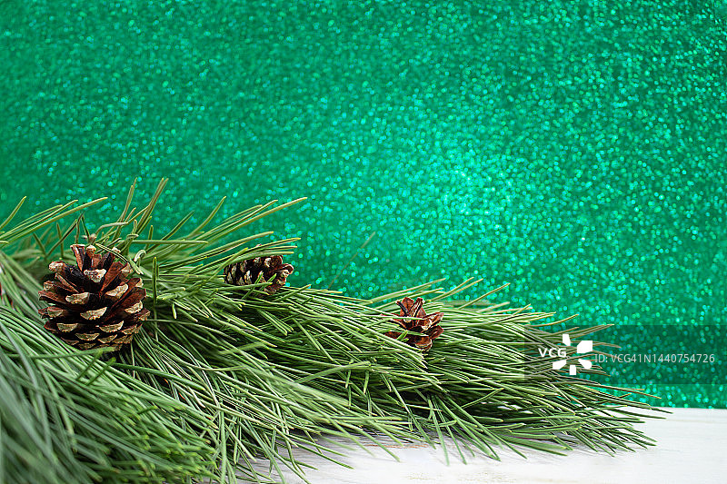 天然松树的树枝和球果在白色的桌子上。模糊的绿色散景。圣诞节，新年。本空间图片素材