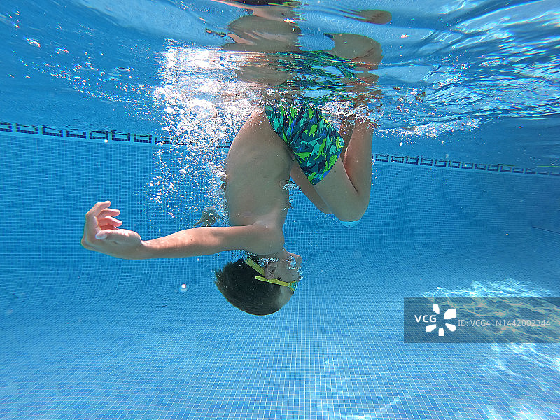 水下拍摄的男孩在游泳池跳水图片素材