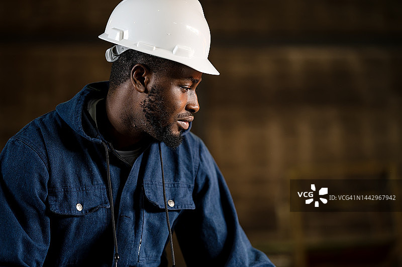 为未来的运营工作建立关键技能。在重工业金属车间工作的非裔美国男性工人的侧视图。图片素材