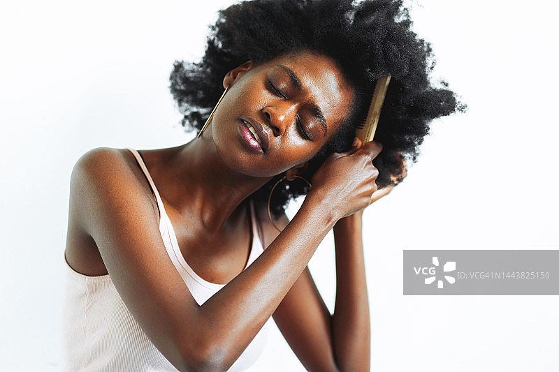 头发和皮肤头部护理。特写女人梳理顽皮的非洲发型图片素材