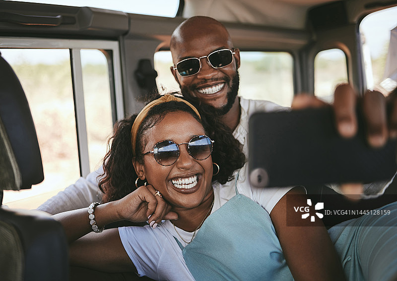 黑色情侣，自拍微笑和手机一起在暑假快乐的旅行公路旅行。快乐的非裔美国男人和女人享受假期旅行，微笑着用智能手机拍照图片素材