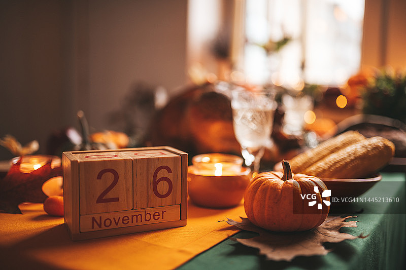 感恩节餐桌上的南瓜和木制日历的秋天装饰图片素材