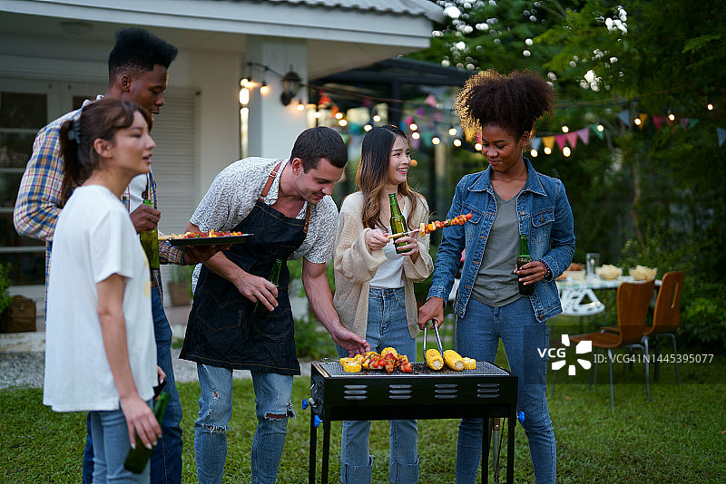 多种族的朋友在后院的聚会上享受烧烤图片素材